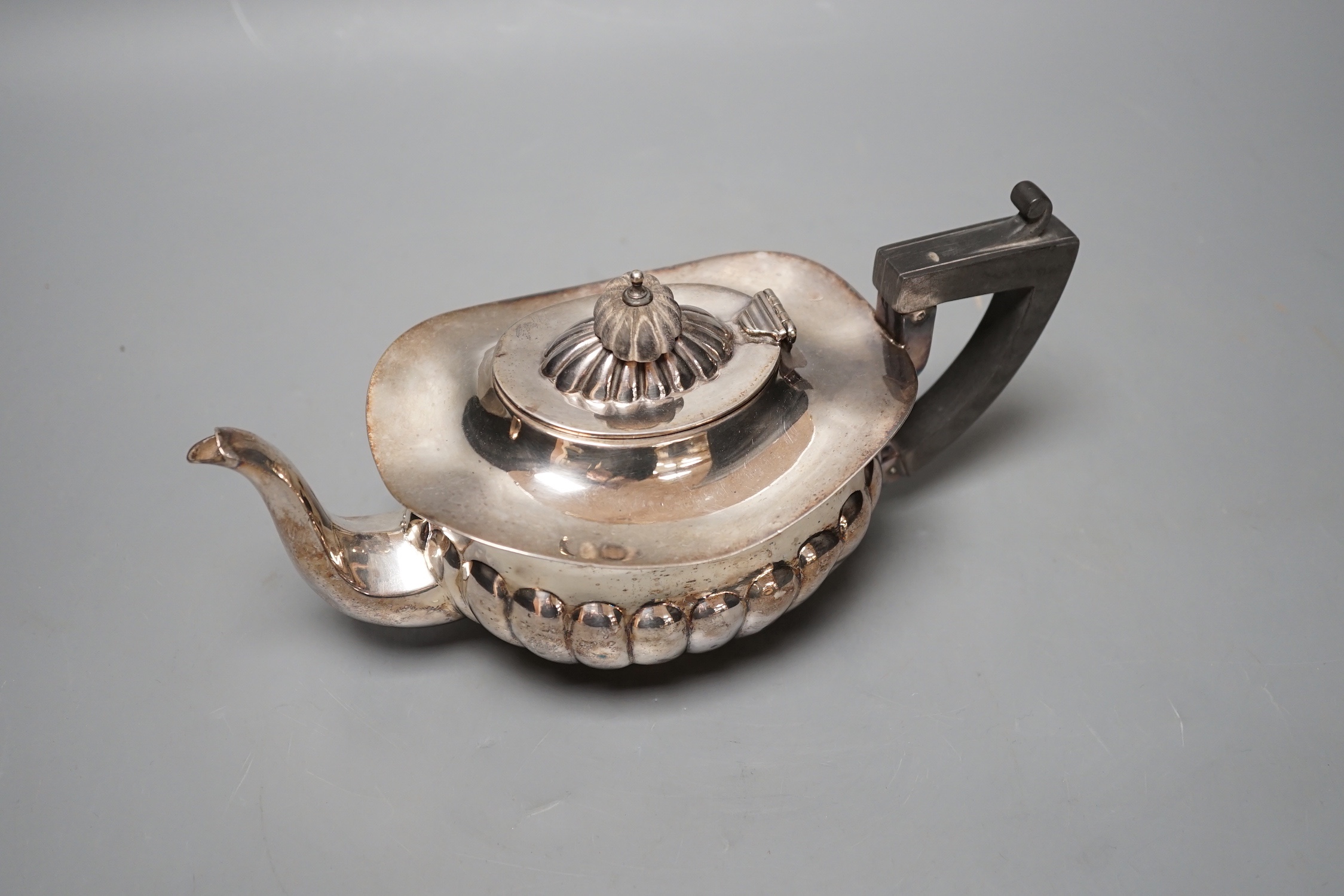 A late Victorian demi-fluted silver teapot, Chester, 1898, gross 10oz.